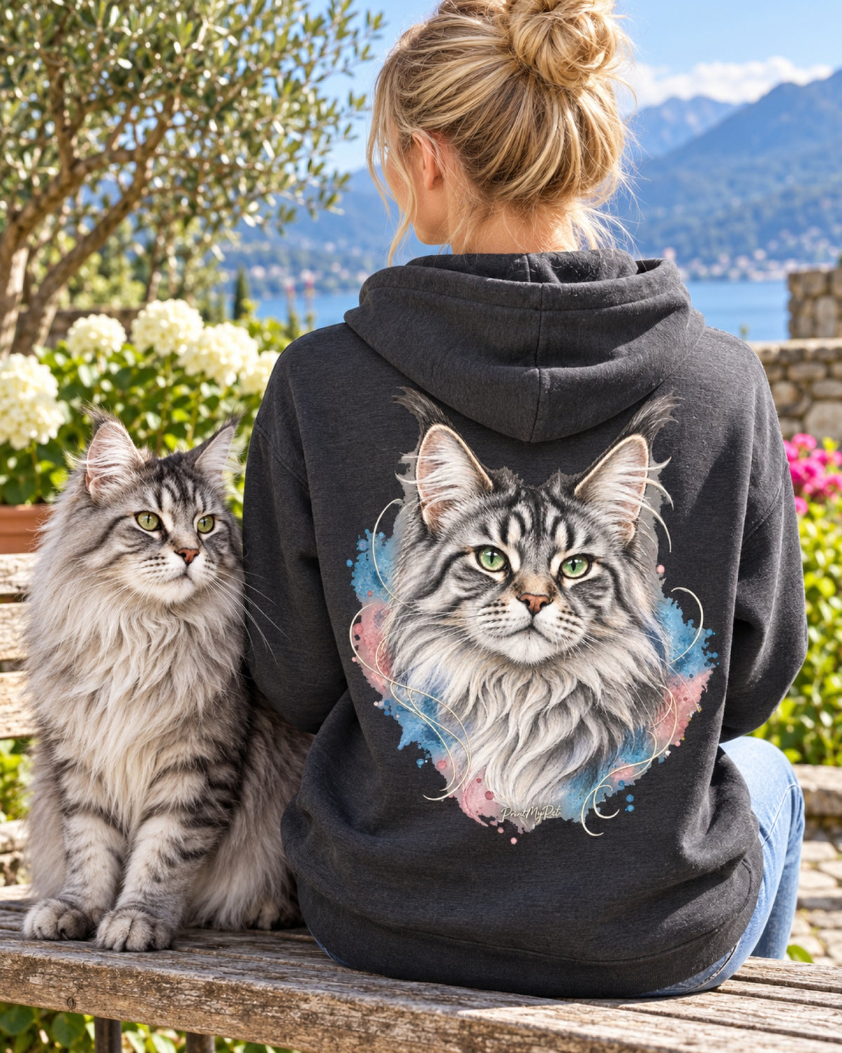Frau im dunkelgrauen Hoodie mit Maine-Coon-Katze im Aquarell-Stil auf dem Rücken, neben ihr ihre Katze