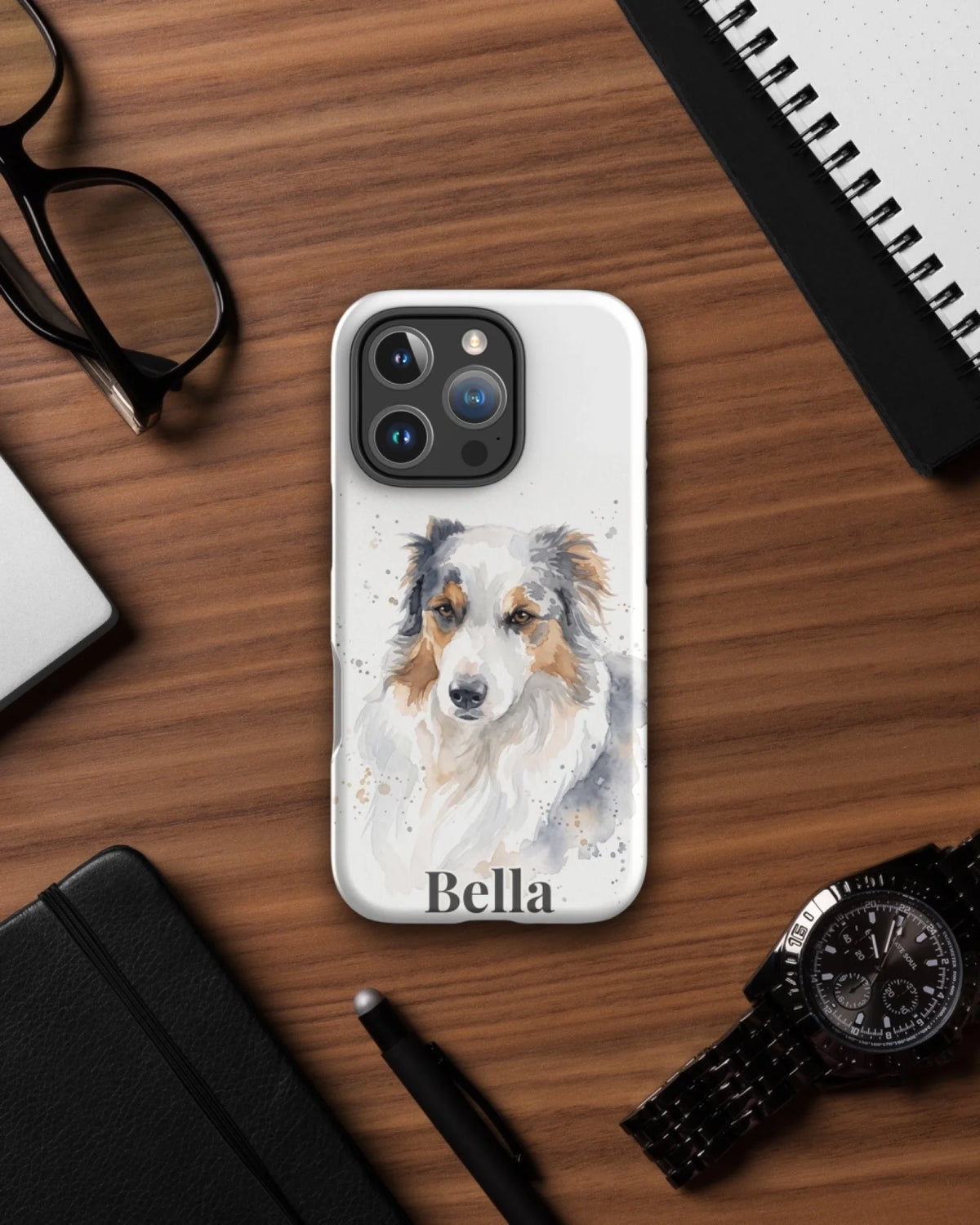 iPhone-Hülle mit Hundeportrait im Aquarell-Stil und Namen Bella auf dem Schreibtisch