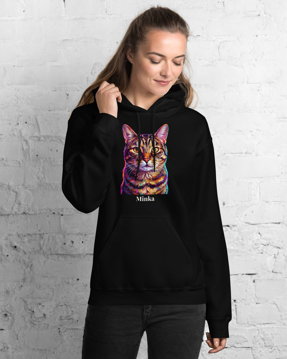 Hoodie in Schwarz mit Portrait von einer Tigerkatze im Stil Pop-Art und dem Namen Minka, getragen von einer Frau