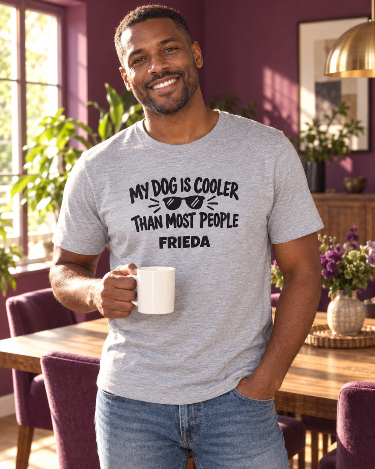 Mann im graumelierten My Dog Is Cooler Than Most People T-Shirt mit Beispielname Frieda im purpurfarbenen Esszimmer