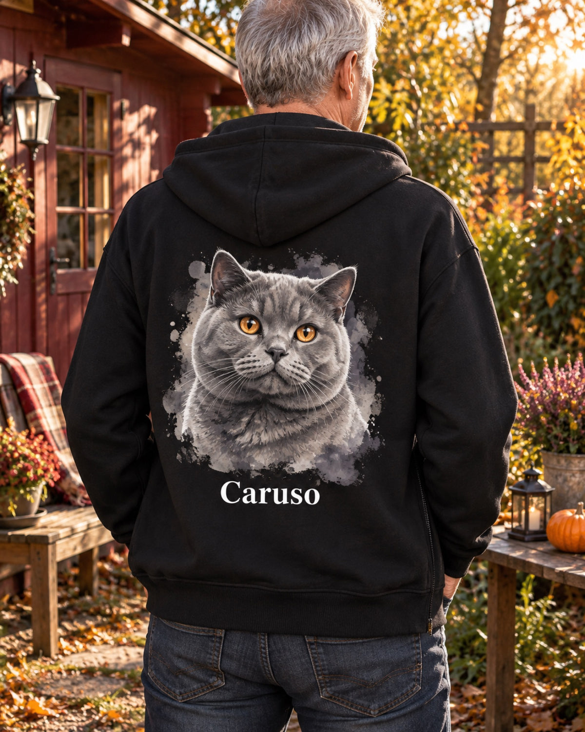 Rückenansicht einer schwarzen Sweatjacke mit grauer Britisch Kurzhaar Caruso als Aquarellportrait im Herbstgarten