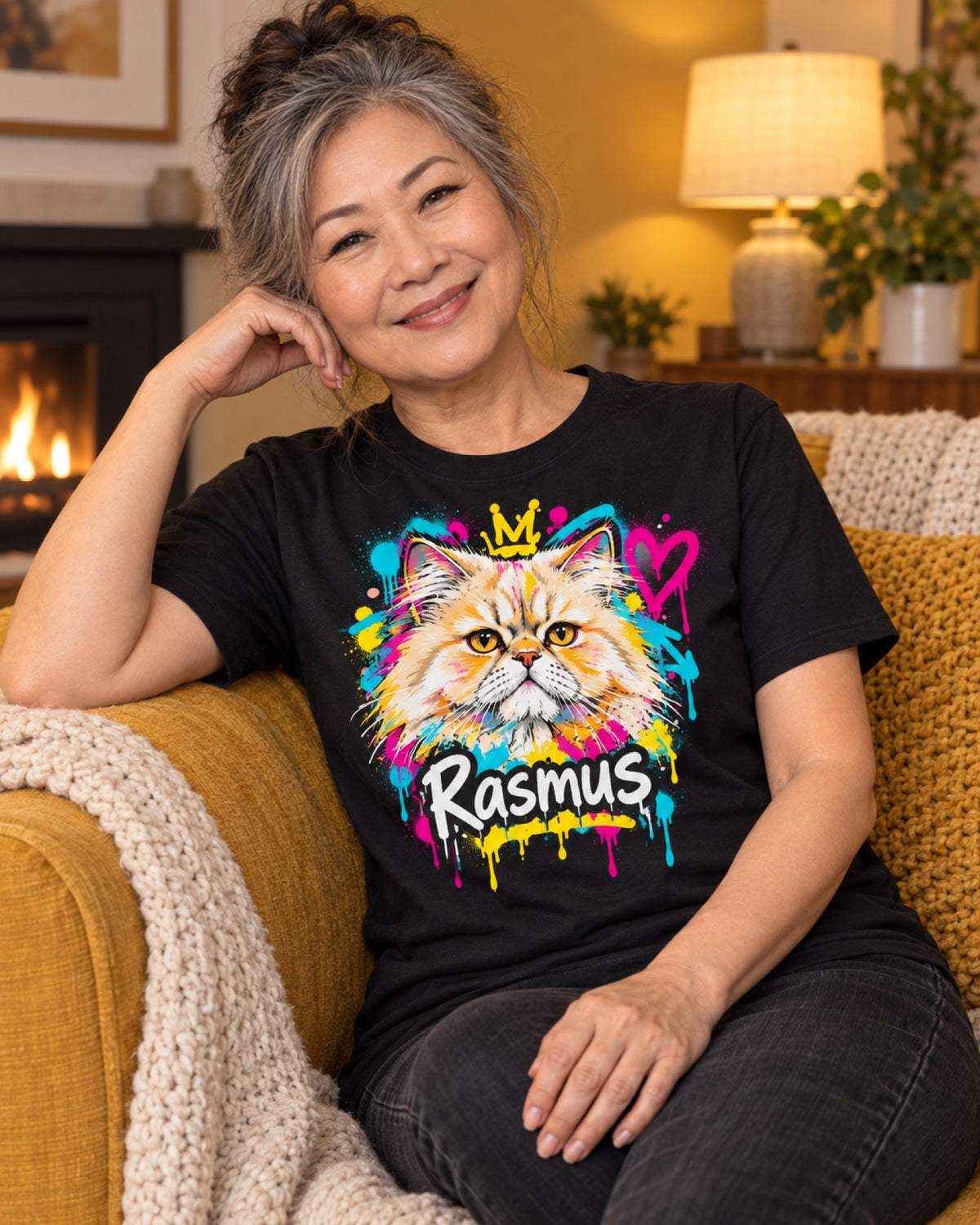 Frau im schwarzen T-Shirt mit Perserkatze Rasmus als farbigem Street-Art-Portrait im senfgelben Winterwohnzimmer