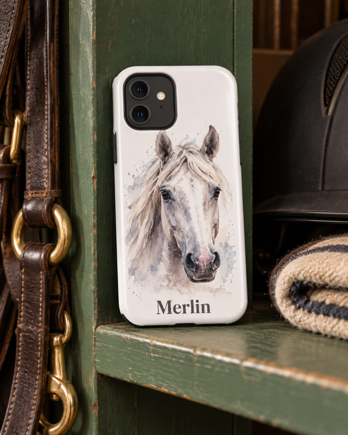 iPhone 11 Hülle mit Schimmel im Aquarell-Stil und Namen Merlin auf einem grünen Holzspind in der Sattelkammer