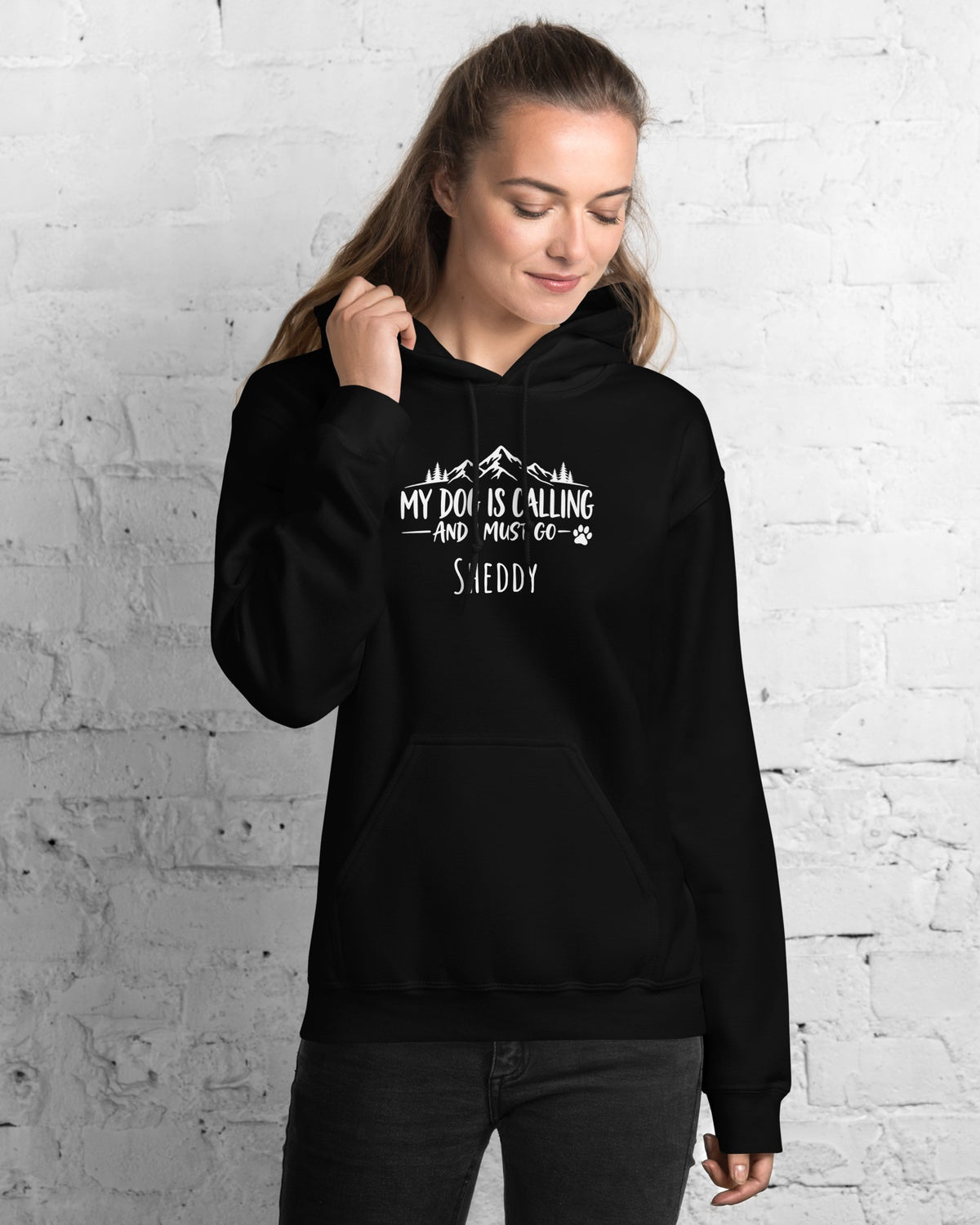 Hoodie My Dog Is Calling in Schwarz mit dem Namen Sheddy, getragen von einer Frau